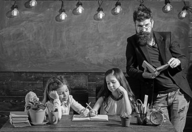 Öğretmen çocuklarla kitaplığındaki kitap okuma