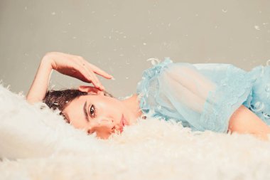 Kız sakin yüzünde tüyler ve kabartmak ile kaplı yatakta yatıyordu. Yumuşak ve nazik bir kavram. Yatak, gri arka plan şeffaf mavi geceliği Bayan yatıyordu. İhale pijama rahatlatıcı uzun saçlı kadın.