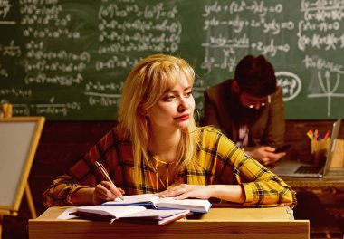 Öğretmen öğrencilerin hedefleri yeniden değerlendirmek zorunda kalacak. Grup öğrenci dersi veren eğitimli profesyonel. Birlikte masada oturan öğrenciler.