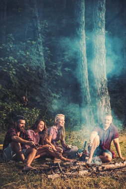 İnsanlar sopa ormandaki doğada, sosis kızartma. Doğada piknik