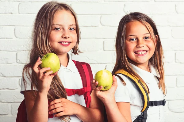 Ragazze felici mangiare mela verde fresca a scuola — Foto Stock