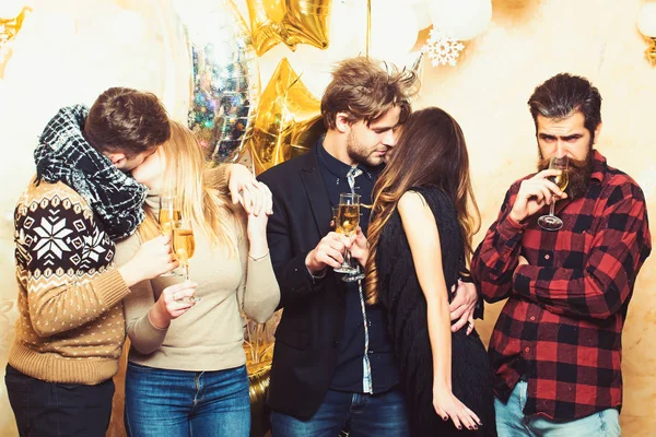 Les femmes et les hommes apprécient la fête. Les amis célèbrent Noël ou le nouvel an. Les hommes et les femmes boivent du champagne. Des couples d'amoureux s'embrassent, des relations. Noël et Nouvel An vacances — Photo