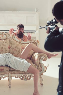 Hipster silahlı yatak odasında görmek için şok. Hipster eller yukarı silah göz ile