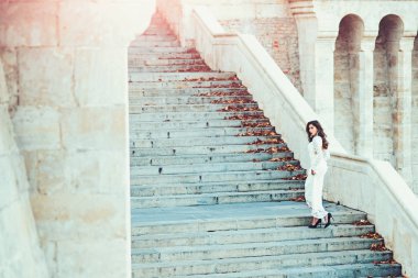Beyaz gelinlik, moda kadın gelin. Şehvetli kadın merdiven üzerinde. Kız glamour bakışla. Merdiven basamakları üzerinde uzun saçlı manken. Mimarlık, yapı ve tasarım