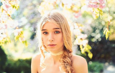 Güzel sevimli ihale genç sarışın kız nazik muhteşem renklerde çiçekli ağaçlar gül bahçesinde. Bayan park güneşli bahar gününde yürür. Hassasiyet kavramı. Genç kadın zevk Bahçe doğada