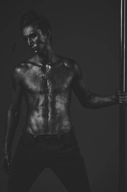 Adam metalik kutubun el koyar. Adam çıplak gövde ile