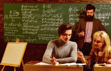Uluslararası öğrenci bireysel çevrimiçi testler yapıyor ve yıllık sınavlar için kompozisyon yazıyor. İnsanlar eğitim ve okul kavramını öğreniyor - öğrencilerin elleri kitaplarla ya da ders kitaplarıyla yazarlık yapıyor
