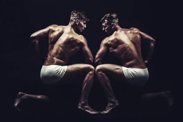 Fitness dieet en flexibiliteit acrobatiek. Twins mannen met gespierd lichaam in pose. Circus gymnasten op pilates of yoga opleiding. Vriendschap van mannen doen gymnastiek. Sport training voor bodybuilder — Stockfoto