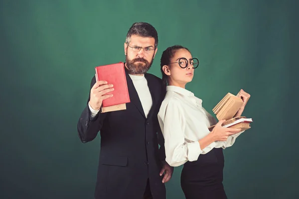 Literaturstunde und Grammatikbuch lesen. Bildung im Wissenstag. Schulzeit von Tochter und Vater in der Bibliothek. Lehrer und Schüler halten Bücherstapel in der Schule. zurück zur Schule und zum Schulbesuch zu Hause — Stockfoto