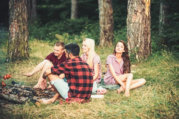 Picnic con amigos en el bosque de verano. Picnic con salchichas asadas al fuego — Foto de Stock