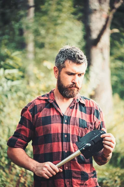 El hombre con camisa a cuadros viaja con pala. Hombre en verde bosque de verano —  Fotos de Stock