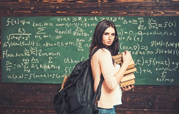 Vue de côté jeune étudiant se préparant à l'examen avec tas de livres de mathématiques en classe. Belle collégienne debout dans la salle de classe — Photo