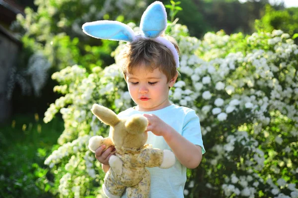 love easter. Family holiday. Little boy child in green forest. Happy easter. Childhood. Rabbit kid with bunny ears. Hare toy. Egg hunt on spring holiday. Funny bunny