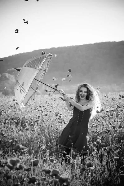 Kırmızı haşhaş alanın üzerinde pembe şemsiye ile mutlu kız — Stok fotoğraf