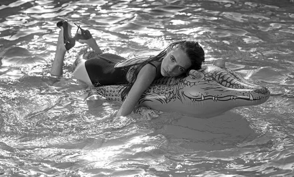 Девушка на надувном матраце крокодила в бассейне — стоковое фото