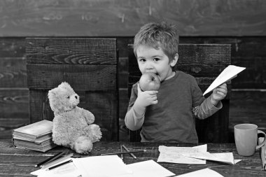 Sulu elma yiyen çocuk. Sarışın çocuk kağıt uçak elinde tutan. Çok güzel çocuk anaokulu