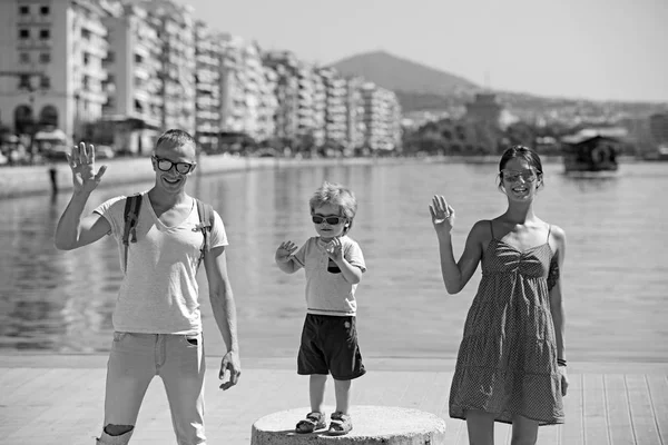 Child with father and mother. child with parents wave on camera. — Stock Photo, Image