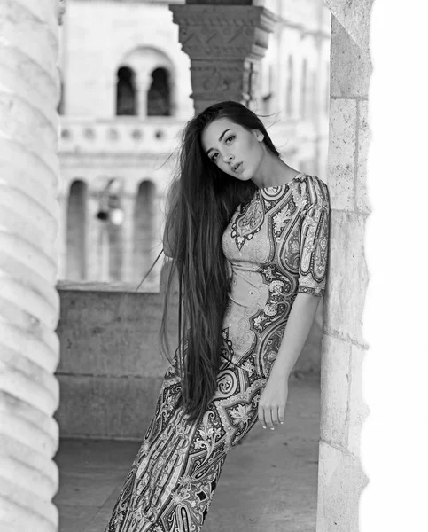 Jeune belle fille élégante posant à la rue de la ville d'été par une journée ensoleillée. Superbe femme en robe violette. Joli modèle aux cheveux longs . — Photo