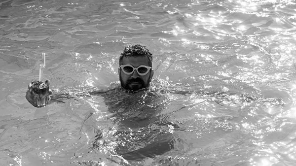 Man drink cocktail in het zwembad in de zomer. Zomervakantie bij swimming pool party — Stockfoto