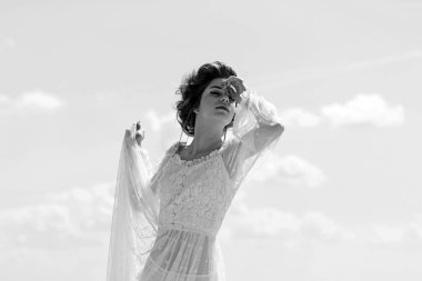 Retro tarzı ve beyaz elbiseli Genç kadın için makyaj. Retro kadın poz mavi gökyüzü arka planda vintage tarzı üzerinde