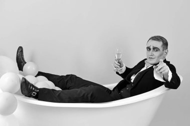 Will you join me. Mime actor enjoy bathing in bath tub. Bathing and relaxing. Mime man has celebration party with champagne. Comedian actor celebrate holidays. Happy bubble bath day clipart