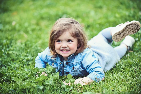 Sonrisa infantil sobre hierba verde — Foto de Stock