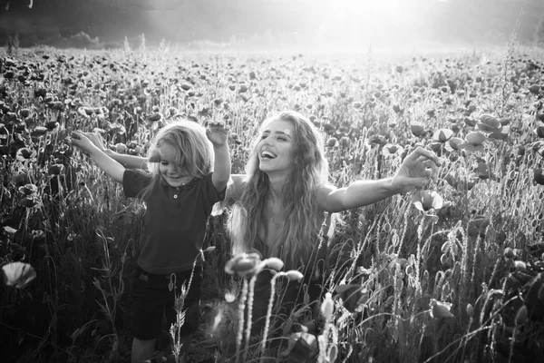 Rouge et vert, mère et enfant souriants dans le champ de pavot — Photo