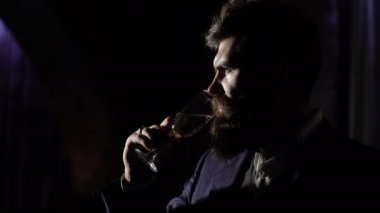 Zarif takım elbiseli girişimci zengin görünüyor. Sakallı adam ya da kendine güveni olan beyefendi şampanya bardağı tutuyor. Zengin yaşam tarzı, moda, zenginlik, kutlama konsepti. Sakallı bir avukat veya politikacı..