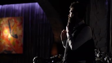 Lüks zengin yaşam tarzı. Zarif takım elbise içinde girişimci zengin görünüyor. Sakallı adam ya da beyefendinin kendine güvenen yüzü, ceketini omzunda tutuyor. Zengin yaşam tarzı, moda, servet, kutlama kavramı.