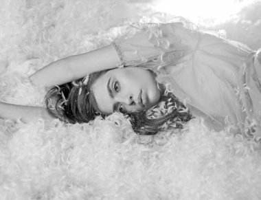 Kız sakin yüzünde tüyler ve kabartmak ile kaplı yatakta yatıyordu. Hafiflik kavramı. Şeffaf mavi Geceliği Bayan tüy yığını yatakta yatıyordu. İhale pijama rahatlatıcı uzun saçlı kadın.