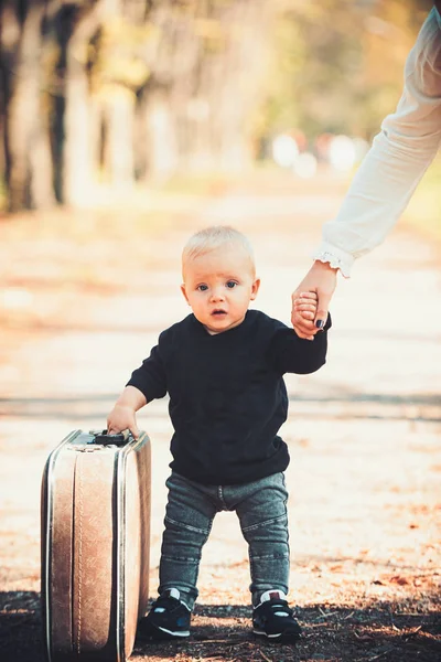 Niedlichen kleinen Jungen mit Koffer auf die Natur. Babyferienkonzept — Stockfoto