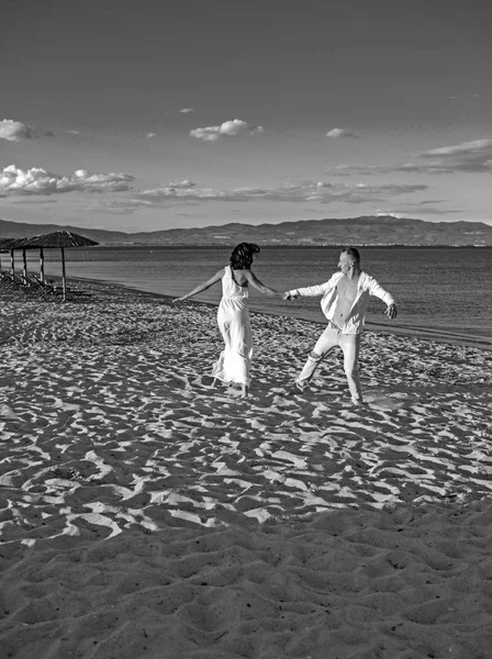 Casal encantador feliz bonito do casamento de paople novo que segura as mãos que estão na água da costa da praia do oceano e dança . — Fotografia de Stock