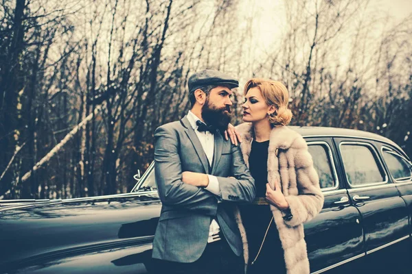 Escortă de fată de la pază. Bărbat cu barbă şi femeie sexy în haină. Călătorie și călătorie de afaceri sau drumeții agățate. Un cuplu îndrăgostit la o întâlnire romantică. Mașină de colectare retro și reparații auto de către șofer mecanic . — Fotografie, imagine de stoc