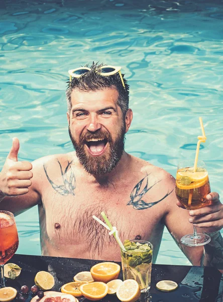 havuz partisi ile suda mutlu sakallı adam. havuz partisi ile alcoholica kokteyller.