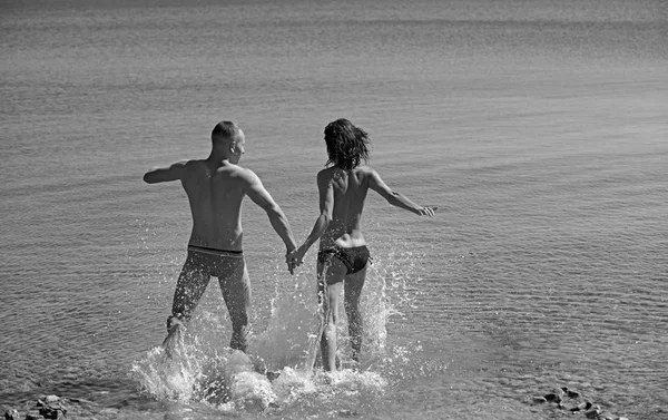 Donna sexy e uomo andare a nuotare in acqua di mare. sexy donna e uomo correre per nuotare . — Foto Stock