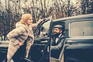 Eskort kız güvenlik tarafından. Sakallı adam ve kürk manto seksi kadın. Çift Romantik tarihte aşık. Retro koleksiyonu araba ve otomatik mekanik sürücü tarafından onarın. Seyahat ve iş gezisi ya da aksaklık hiking.