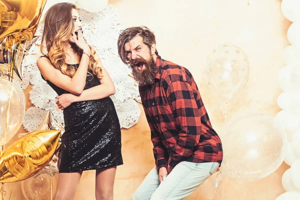 Donna sensuale e uomo barbuto sorridono con palloncini, Natale. Hipster e donna a Capodanno o la vigilia di Natale. Coppia innamorata godere festa festa festa. La famiglia felice festeggia il Natale e l'anno nuovo — Foto Stock