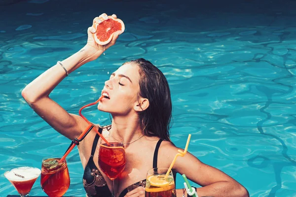 Zomervakantie en zwemmen op zee. Drink verse vitamine SAP, dieet. Mode vrouw met vernieuwen alcohol in miami. Zwembad partij ontspannen in een kuuroord. Cocktail met fruit op sexy meisje in zwembad op Malediven. — Stockfoto
