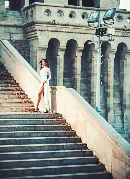 Jeune femme en robe longue blanche monter l'escalier — Photo