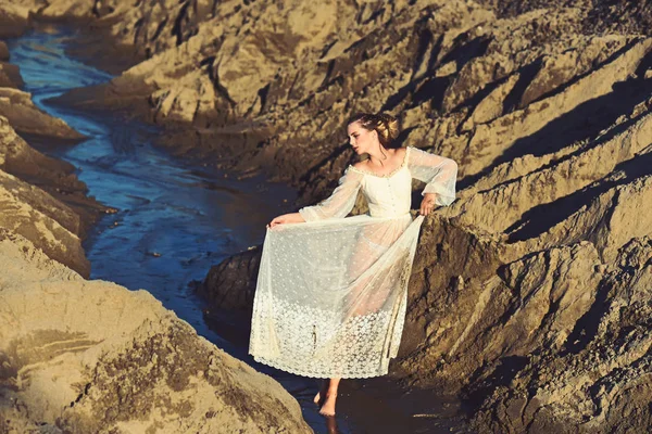 Woman in white dress pose in water, fashion