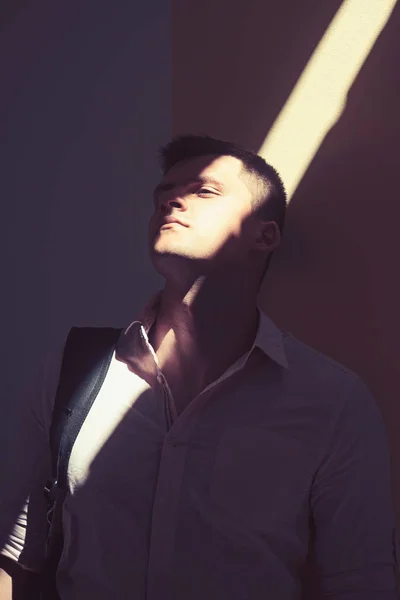 Мужчина носит модную рубашку на солнечной стене моды. Человек со стильными волосами на открытом воздухе — стоковое фото