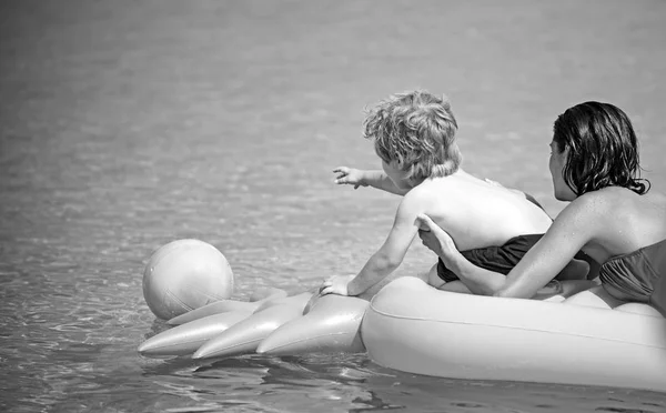 Mujer con niño nadar en colchón de aire amarillo en el agua en el verano . —  Fotos de Stock