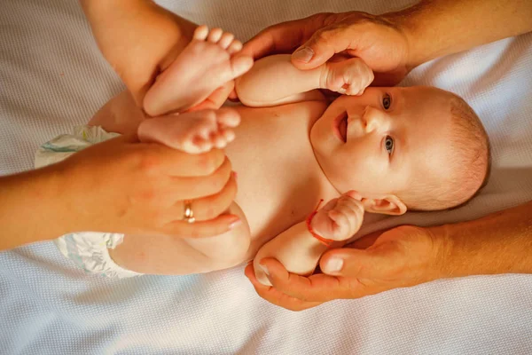 Porque el cuidado comienza en la familia. Bebé recién nacido dado masaje por los padres. Cuidado del bebé recién nacido. Feliz crianza. Ser padre es un reto. Permítete ser un padre feliz para el niño y para ti mismo — Foto de Stock