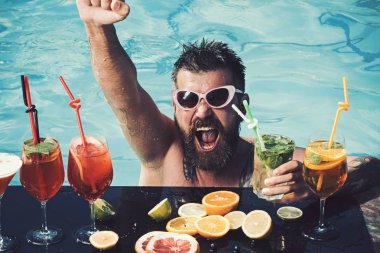 Adam yüzme ve içecek alkol. Havuz partisi, vitamin ve diyet. Miami veya Maldivler tatil yaz. Havuzda sakallı adam meyve kokteyli. Deniz ve spa resort sakin ol.