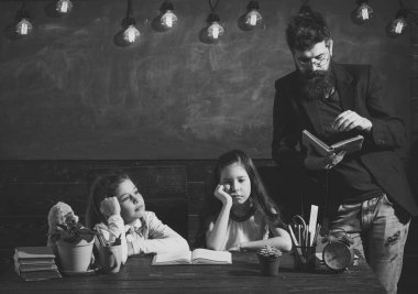 Sıkıcı ders kavramı. Sakallı adam kız öğrenciler, kitap okuma öğretir. Bıkkın ve yorgun çocuk öğretmen dinleme. Öğretmen ve kız öğrencilerin sınıfta, kara tahta arka plan.