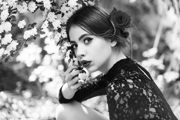 Menina bonito com lábios vermelhos posando com flores brancas florescentes — Fotografia de Stock