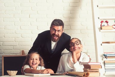 İlkokul çocukları ve Öğretmen sınıfta oturup.