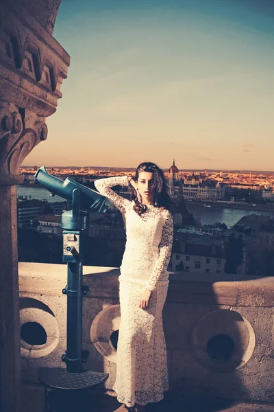 Hochzeitsmode Frau mit Teleskop am Aussichtspunkt auf das Stadtbild. Modelreisen im Urlaub, Hochzeit — Stockfoto