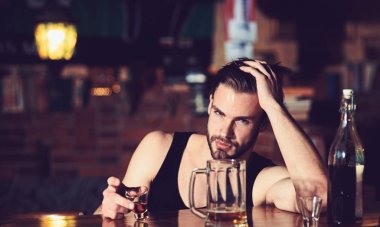 Alkol onu relax yardımcı olabilir. Kısa alkol içki ile alkol bağımlısı. Alkollü adam adlı bar counter içme. Adam içki güçlü alkollü içecek ve bira barda. Kötü alışkanlık