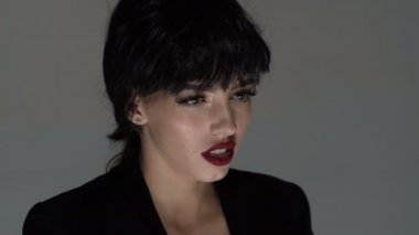 Gri arka planda izole edilmiş kırmızı dudaklı esmer kadın çığlık atıyor. Oyunculuk sanatı kavramı. Çaresiz kadın keder içinde çığlık atıyor. Bağıran güzel bir kızın portresi. Kadın bağırıyor, panik, çığlık.